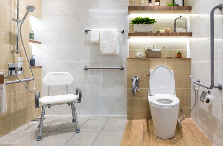 Bathroom renovations for the elderly and disabled in Hornsby by Quality Bathroom Renos with a modern handheld shower, shower seat, and a raised accessible toilet.