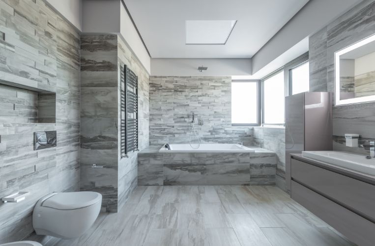 Custom bathroom renovations in Hornsby by Quality Bathroom Renos with a built-in spa bath, stone feature walls, and natural light.